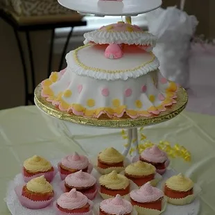 This baby shower cake is covered with fondant, cup cakes are topped with buttercream icing. The elephant and hood was hand made