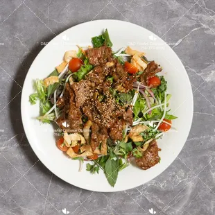 Spicy Beef Salad 
Beef, mixed greens, cilantro basil, onion, tomatoes, carrot, bean sprouts, spicy dressing.