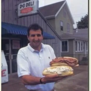 a man holding two sandwiches