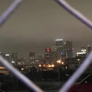 a view of a city through a chain link fence