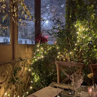 a patio with a table and chairs and christmas lights
