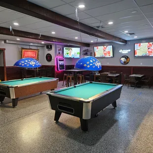 two pool tables and a television