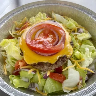 a hamburger with lettuce, tomato and cheese