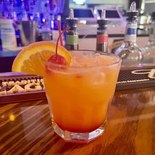 a glass of orange juice on a bar