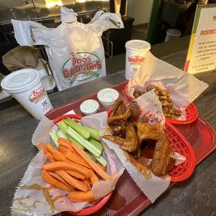 a tray of chicken wings and carrots