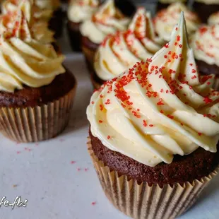chocolate cupcakes with white frosting and sprinkles