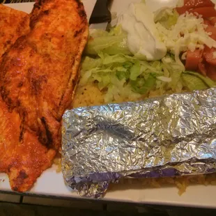 a plate of food with chicken, lettuce, tomatoes, and a salad