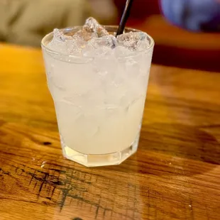 a glass of lemonade on a wooden table