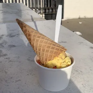 Banana ice cream with peanut butter on top, cherry below.