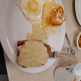 a plate of eggs, sausage and gravy