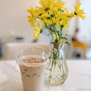 a cup of coffee and a vase of flowers