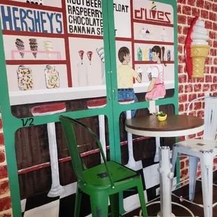 a table and chairs in front of an ice cream parlor