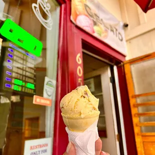 a hand holding an ice cream cone