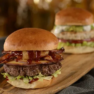 two burgers on a wooden board