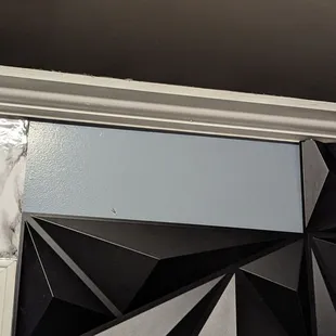 Missing tile piece, tile visible on shelf in same room