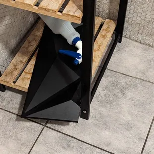 Wall tile in shelf with spray bottle on top of it in bathroom