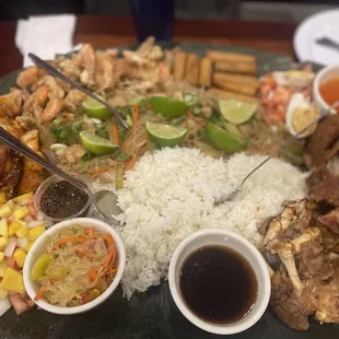 Family size Kaboodle platter of rice, pancit, fried shrimp, lumpia, lechon, chicken, aychara, and tomato/onion/egg/mango salad