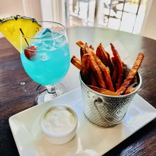 a bowl of fries and a cocktail
