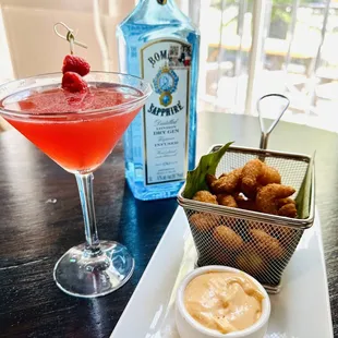 a cocktail and a basket of fried shrimp