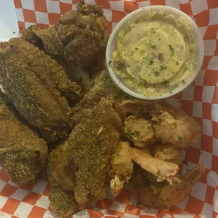 a basket of fried wings and a side of dip