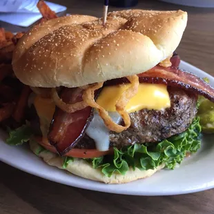 a hamburger with bacon, cheese, and lettuce