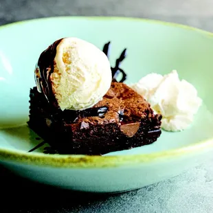 a chocolate brownie with ice cream on top