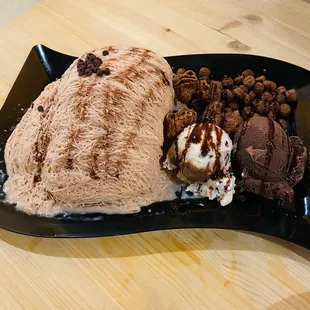 Chocolate bingsu plate with two scoops ice cream, condiments on sides