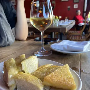 a plate of bread and a glass of wine