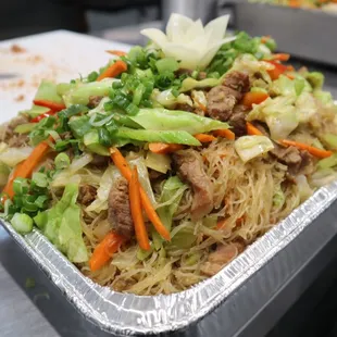 a tray of noodles with meat and vegetables