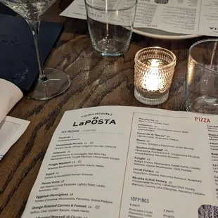 a menu and wine glasses on a table