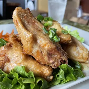 a plate of chicken wings and lettuce