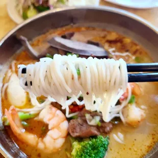 a bowl of noodles with shrimp and broccoli