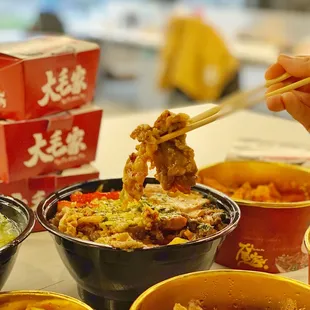 a person eating a bowl of noodles with chopsticks