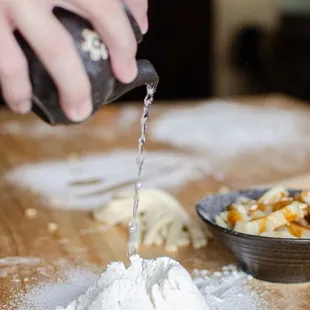 a person pouring water into a bowl of food