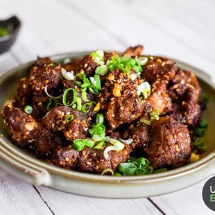 a plate of meat with green onions