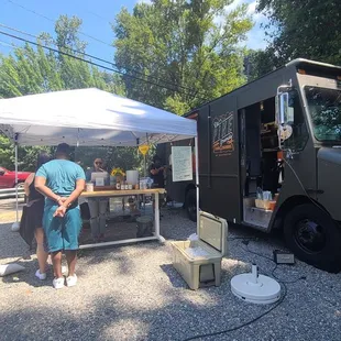 a man and a woman standing in front of a food truck