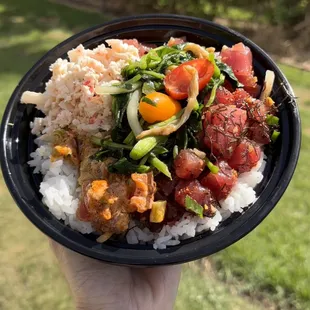 a hand holding a bowl of food