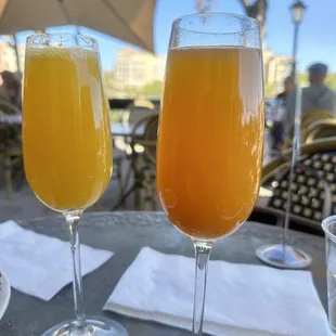 two glasses of orange juice on a table