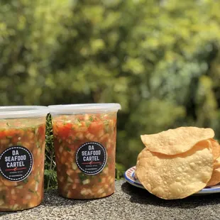two cups of salsa and a plate of chips
