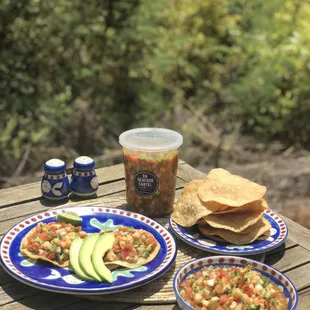 two plates of food and a drink on a picnic table