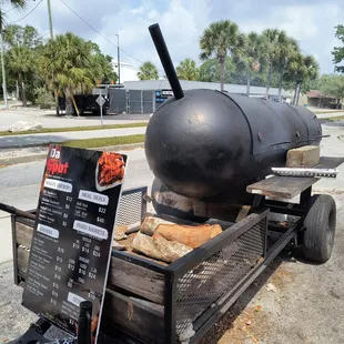 a bbq on a cart with a menu