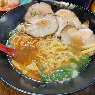 a bowl of ramen with meat and vegetables