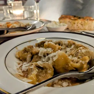 Agnolloti with lamb front, glimpse of the Scialatelli clams and bread with tallegio butter in the back