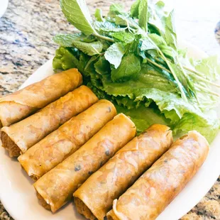 a plate of spring rolls with lettuce