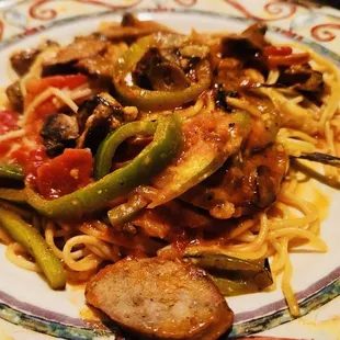 a plate of pasta with sausage and peppers