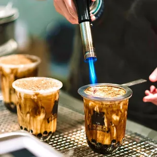 a person pouring coffee into two cups