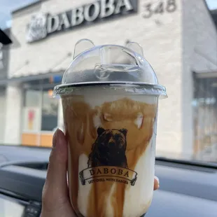 a hand holding a cup of iced coffee
