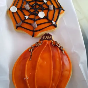 a pumpkin and spider web cookie