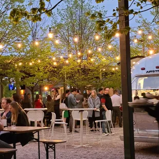 people sitting at tables under string lights