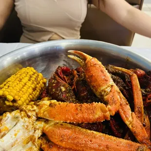 a plate of crab legs and corn on the cob